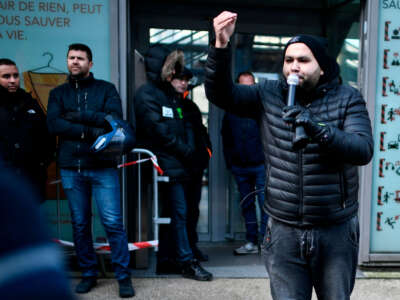 Sud Rail union member Anasse Kazib delivers a speech as rail workers gather during a general meeting at the Gare du Nord station in Paris, on December 10, 2019.